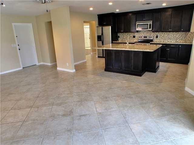 1400 Southwest 2nd Street Boca Raton, FL 33486 - Photo 9 of 9 a kitchen with stainless steel appliances granite countertop a stove top oven a sink a counter top space and cabinets
