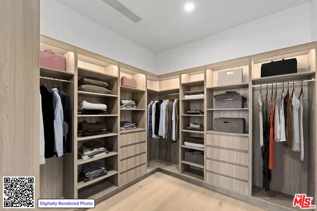 a view of walk in closet with clothes and shoes