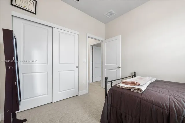 a bedroom with a bed and a refrigerator