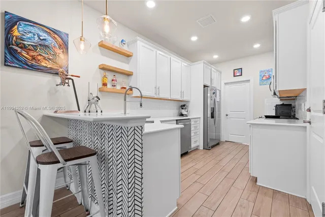 a kitchen with a sink appliances cabinets and furniture