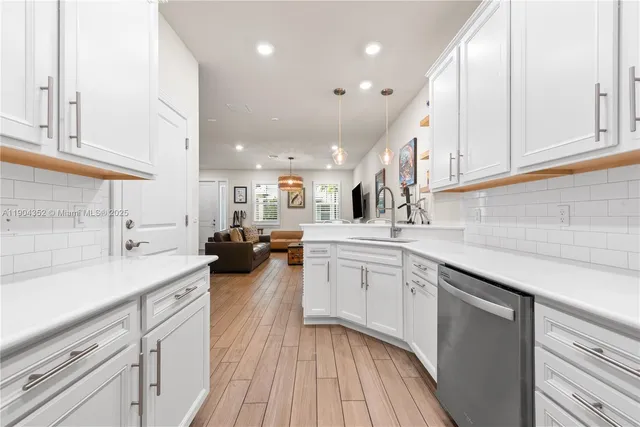 a kitchen with lot of cabinets and wooden floor