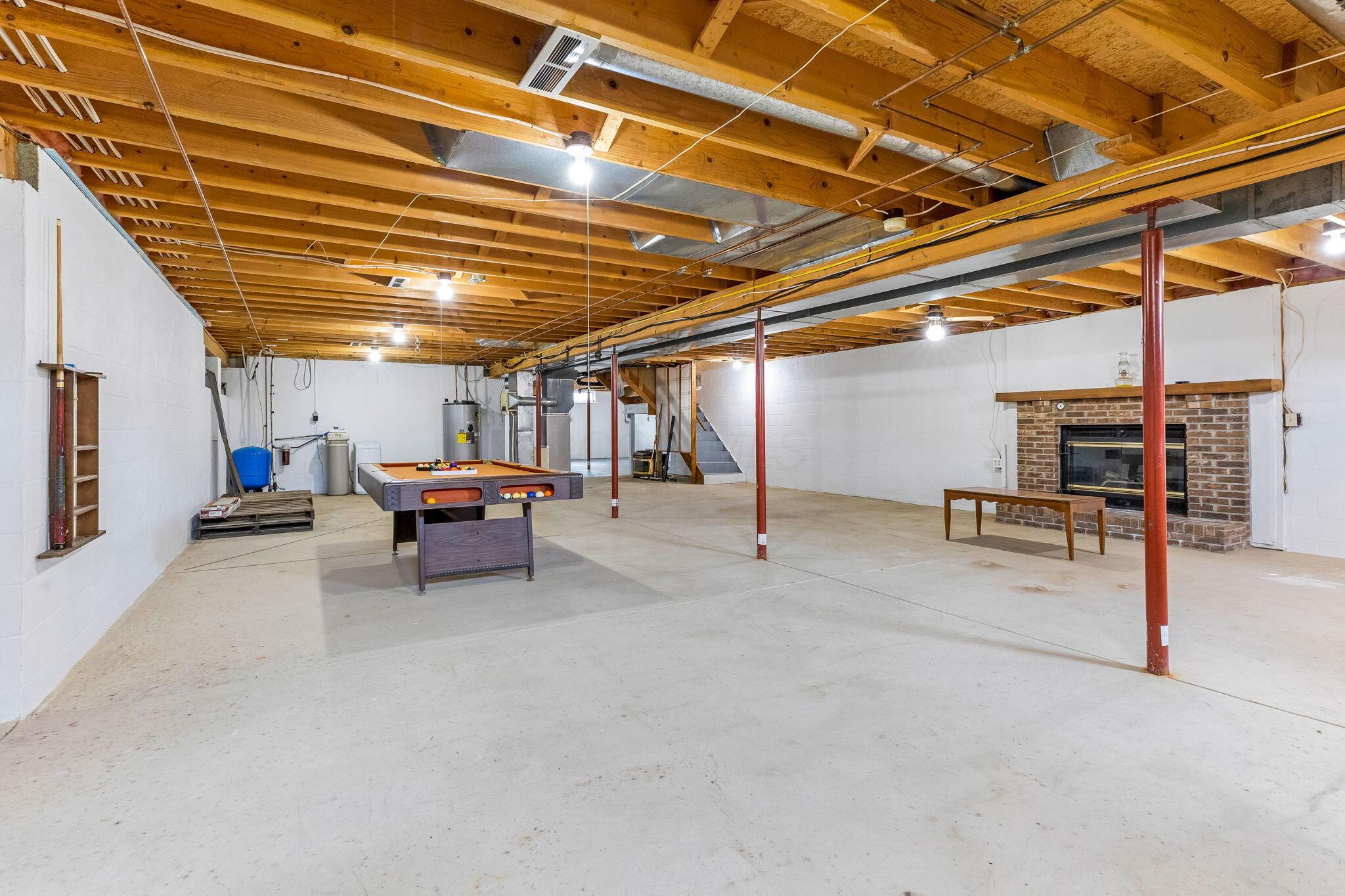 6651 Lancaster Road Hebron, OH 43025 - Photo 57 of 88 A spacious basement ready to finish to your liking, already featuring a cozy fireplace and a pool table—making it the perfect space for entertaining, relaxing, or creating your dream rec room.