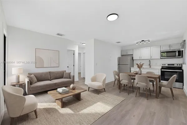 a living room with furniture and a dining table with kitchen view