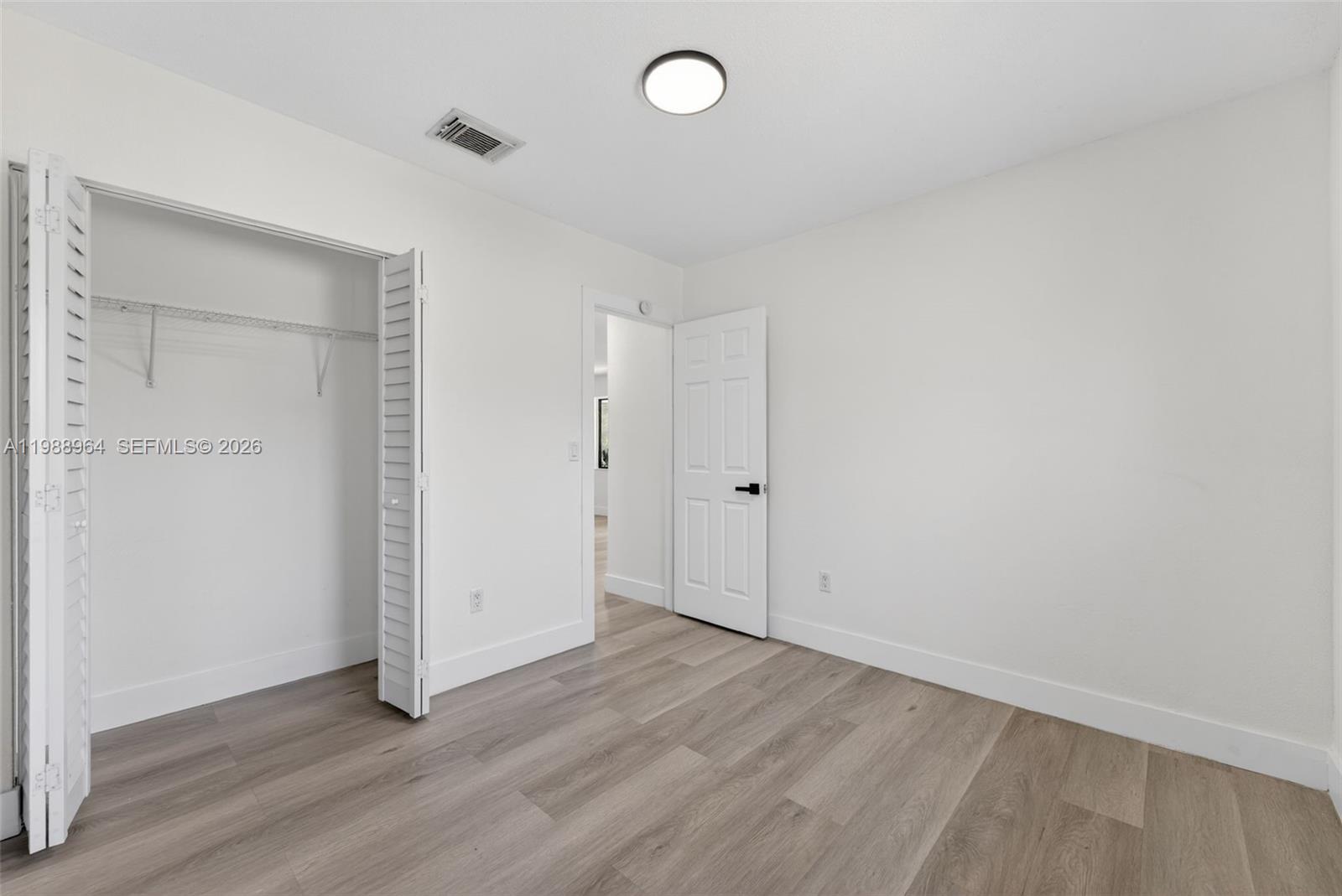37 Northwest 59th Street, Unit 7 Miami, FL 33127 - Photo 16 of 19 an empty room with wooden floor and windows