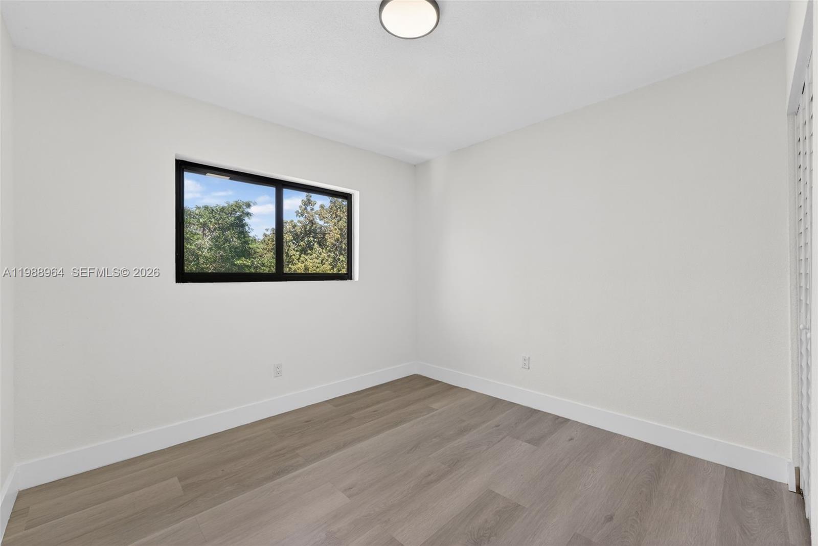 37 Northwest 59th Street, Unit 7 Miami, FL 33127 - Photo 17 of 19 an empty room with wooden floor and window