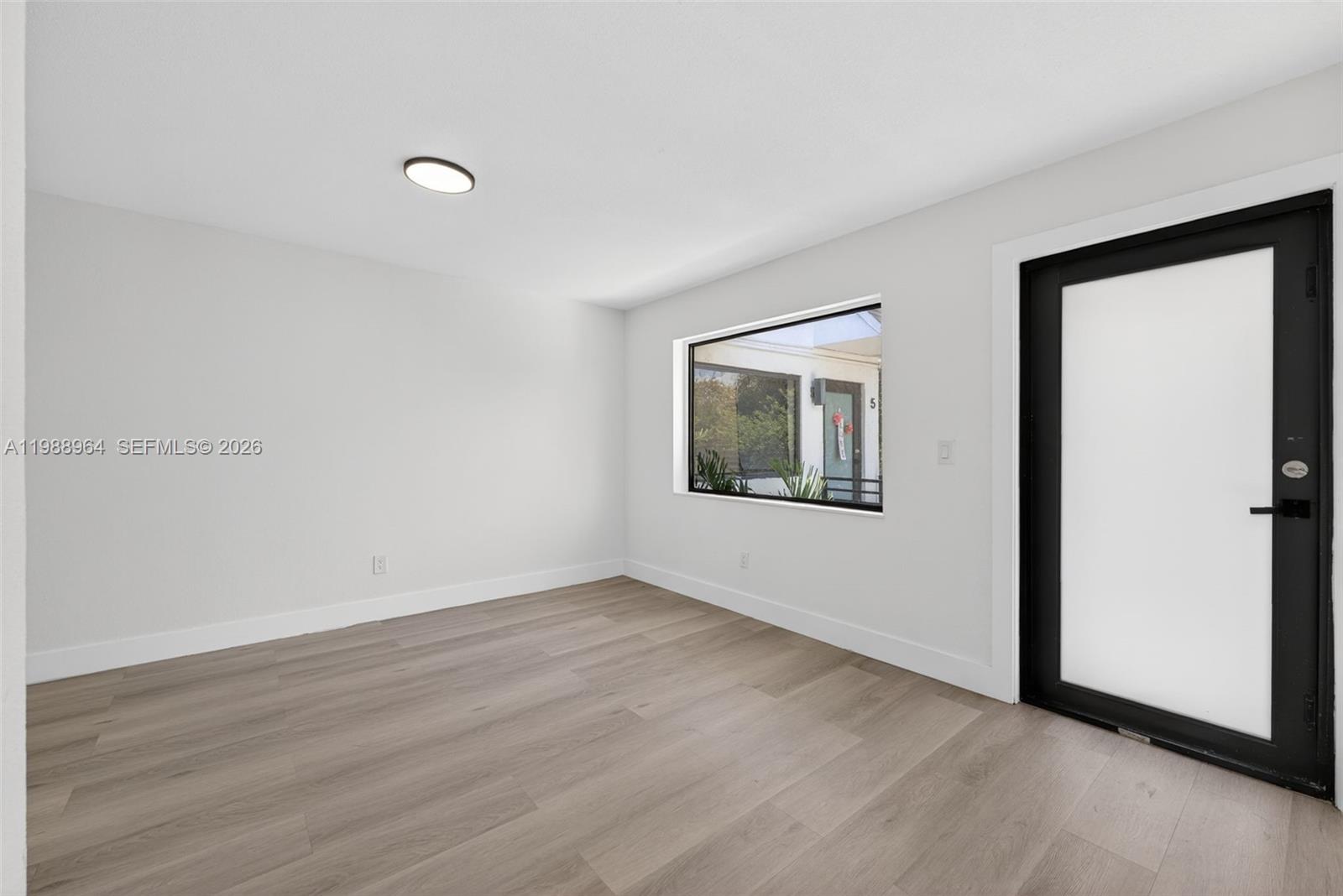 37 Northwest 59th Street, Unit 7 Miami, FL 33127 - Photo 9 of 19 a view of an empty room with wooden floor and a window
