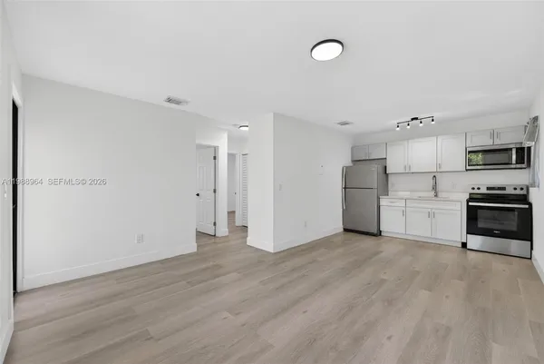 a view of kitchen with stainless steel appliances a refrigerator and a stove top oven