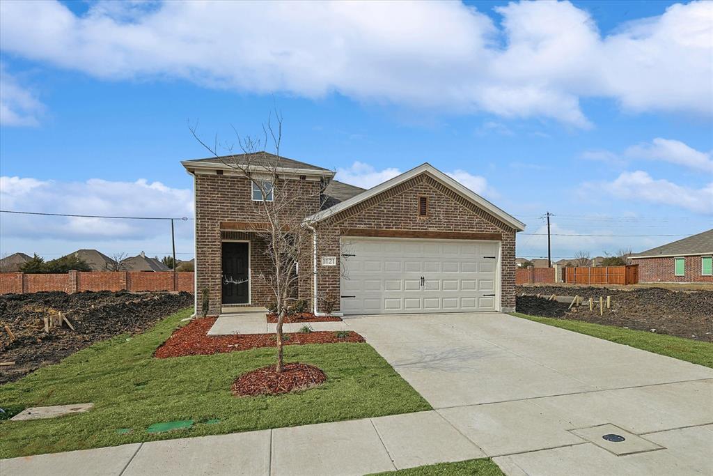 Traditional-style house featuring brick siding, concrete driveway, and an attached garage