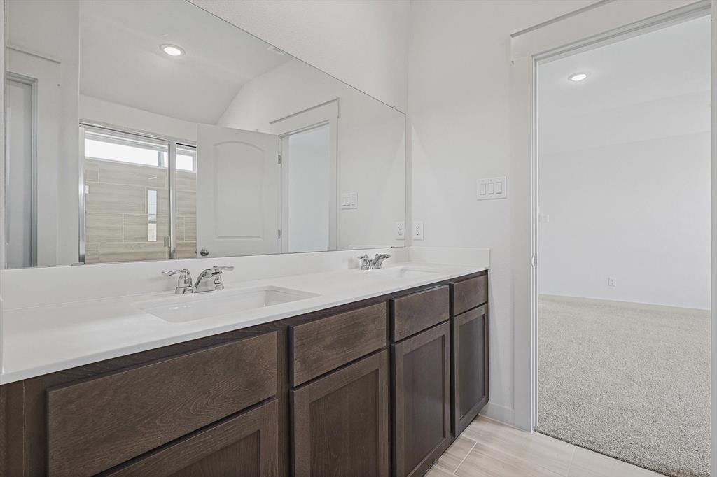 1714 Glacial Beech Place Forney, TX 75126 - Photo 15 of 25 Bathroom featuring double vanity, light colored carpet, a shower with shower door, lofted ceiling, and recessed lighting
