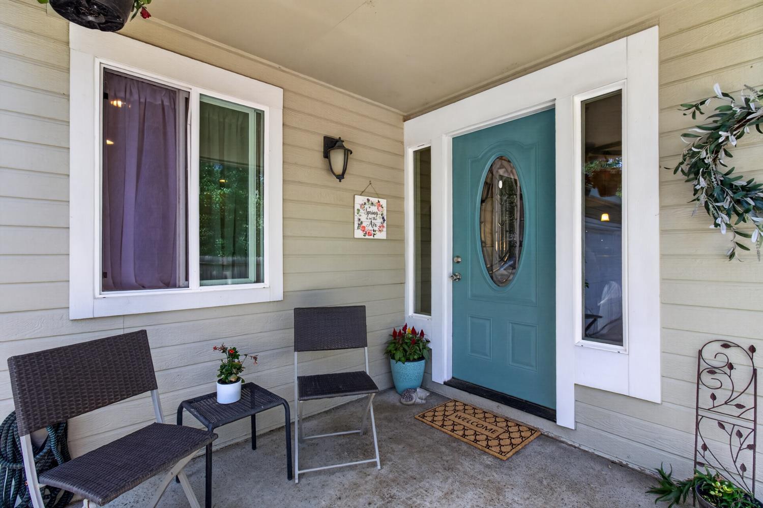 6332 Horseshoe Bar Road Loomis, CA 95650 - Photo 4 of 85 Covered front porch featuring a teal oval-lite entry door, vertical sidelites, and horizontal siding