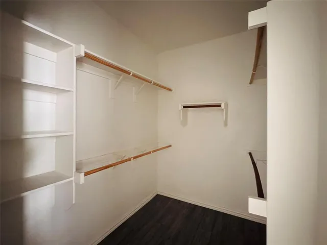 a view of walk in closet with wooden floor