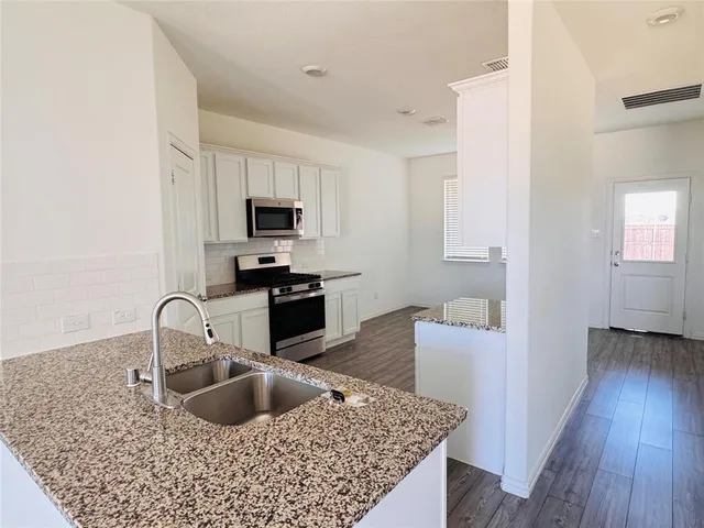 a kitchen with a sink cabinets and a wooden floor