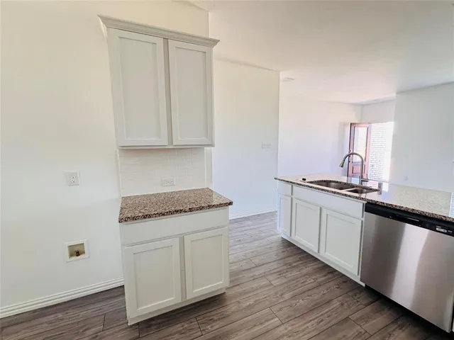 a kitchen with granite countertop white cabinets and a stove