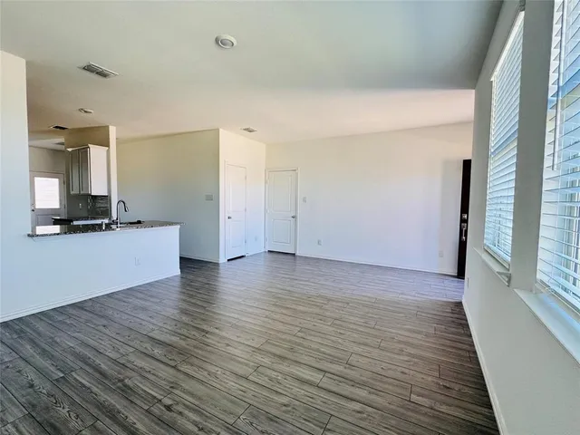 a view of a room with wooden floor and a window