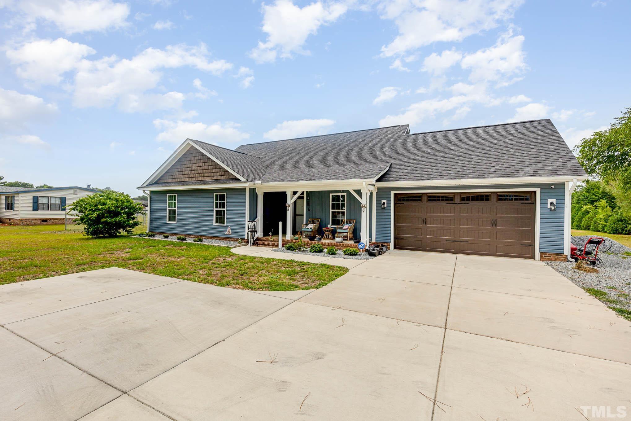 6551 Faircloth Bridge Road Stedman, NC 28391 - Photo 1 of 30 a front view of a house with a yard and garage