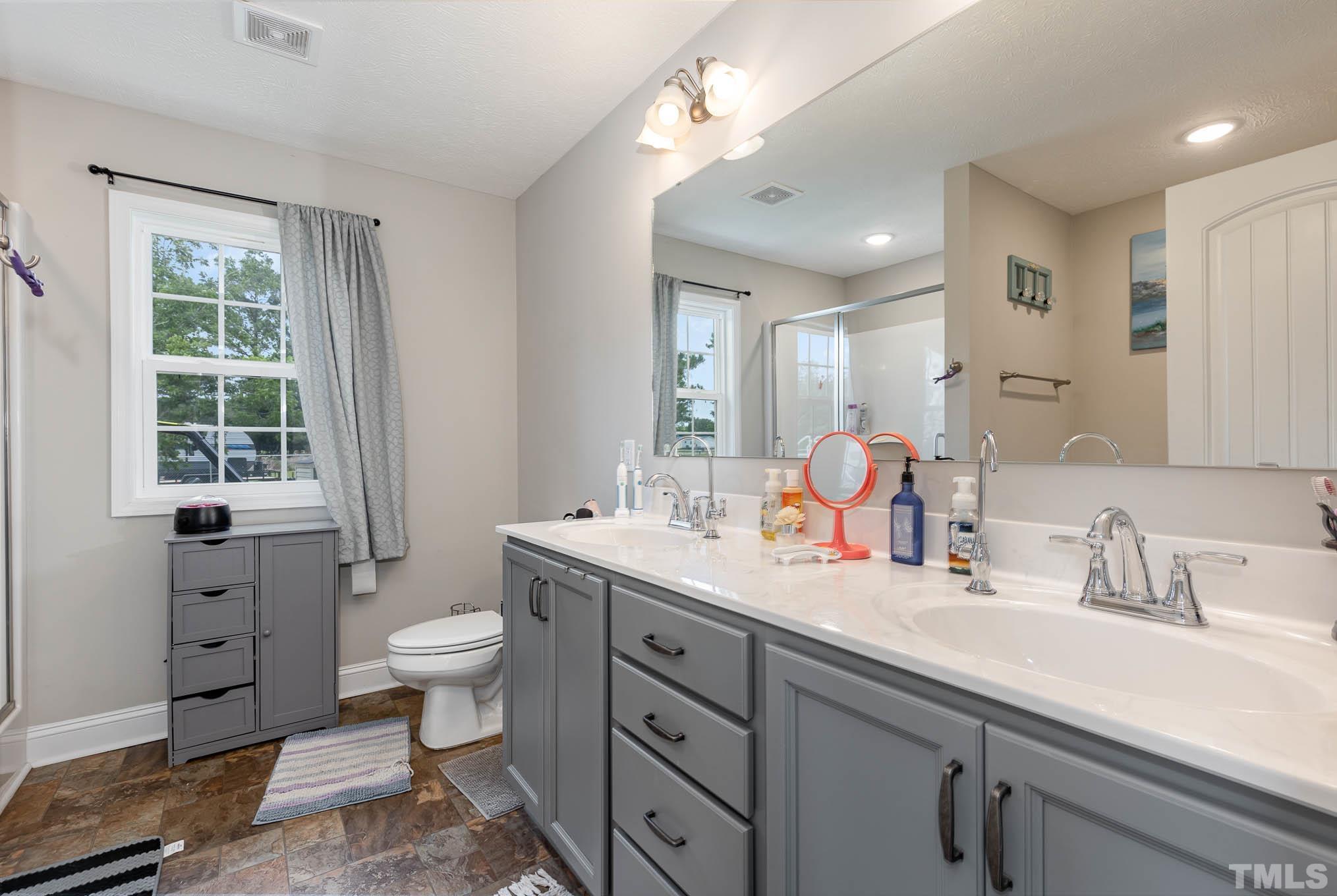 6551 Faircloth Bridge Road Stedman, NC 28391 - Photo 17 of 30 a bathroom with a toilet sink double vanity and mirror