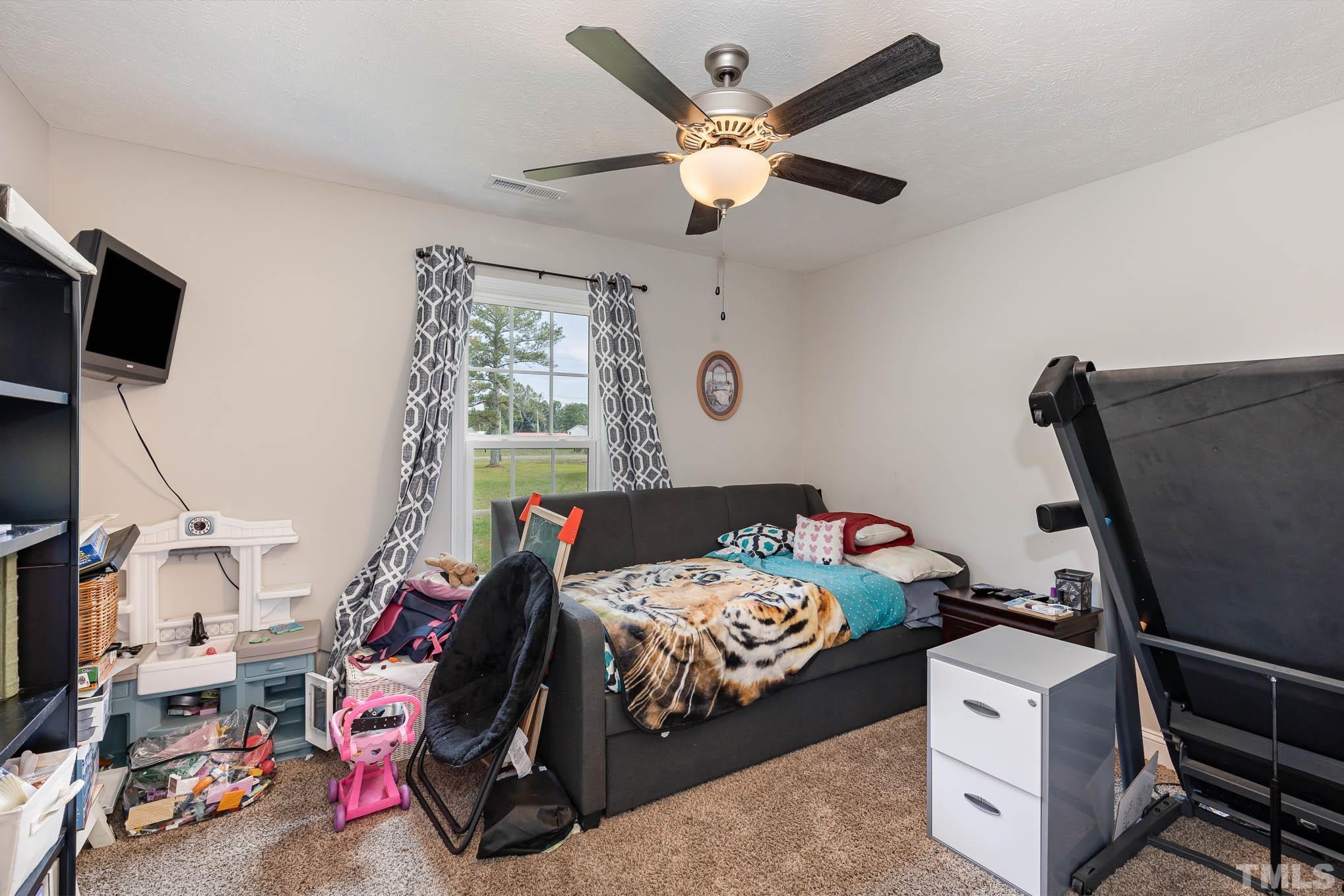 6551 Faircloth Bridge Road Stedman, NC 28391 - Photo 20 of 30 a bedroom with a bed and a flat screen tv