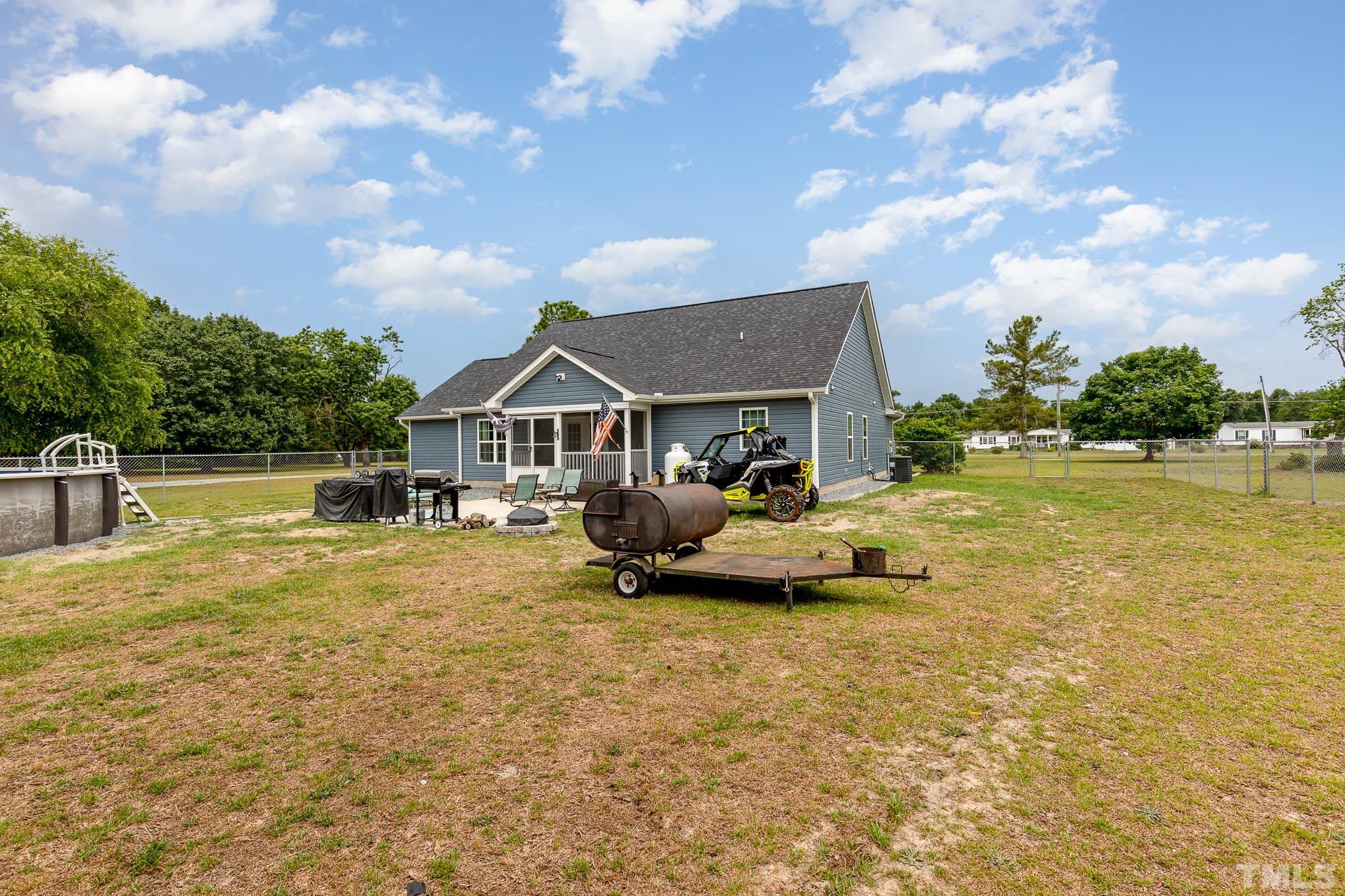 6551 Faircloth Bridge Road Stedman, NC 28391 - Photo 27 of 30 a backyard of a house with table and chairs
