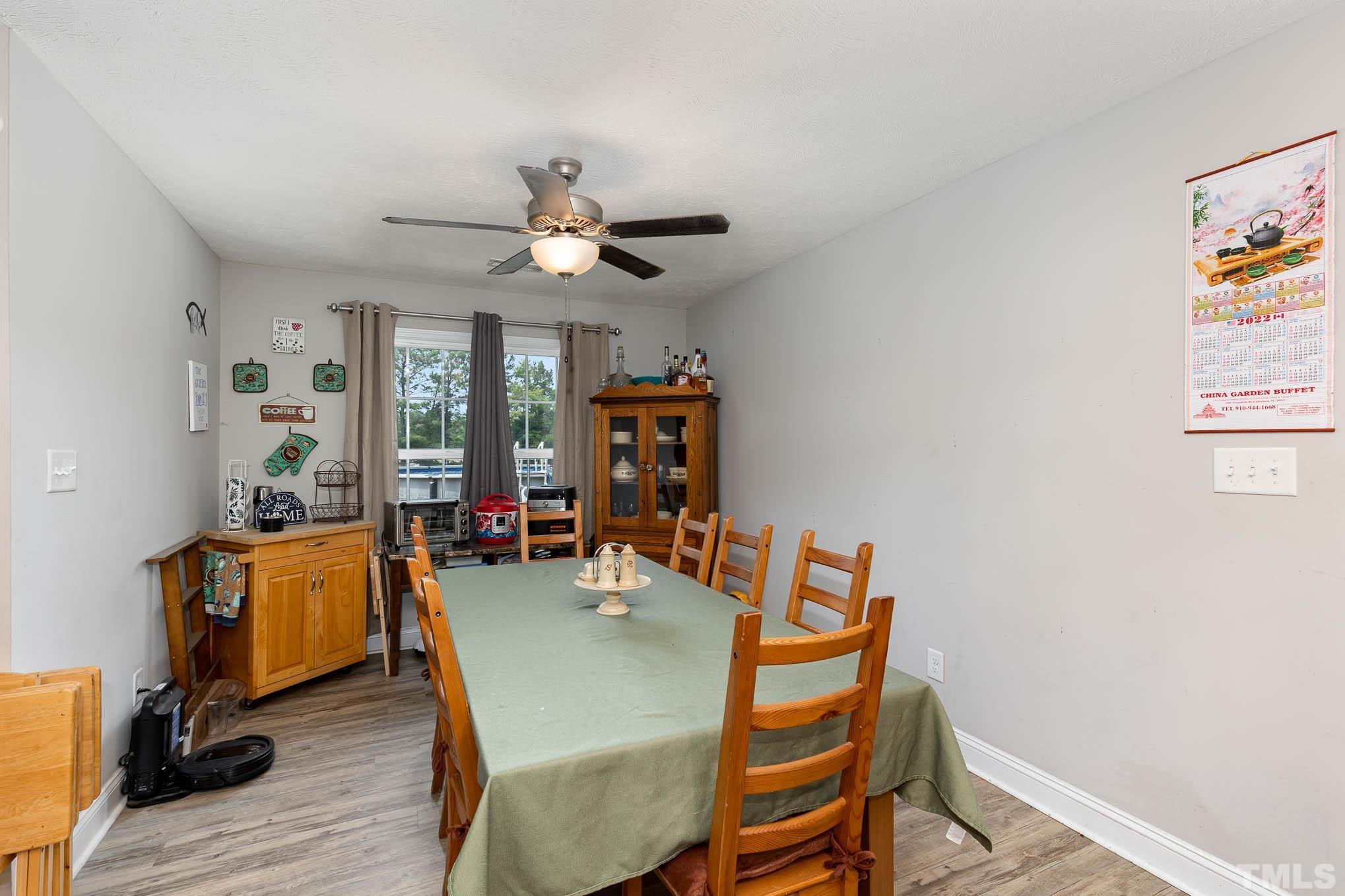6551 Faircloth Bridge Road Stedman, NC 28391 - Photo 9 of 30 a dining room with furniture and wooden floor