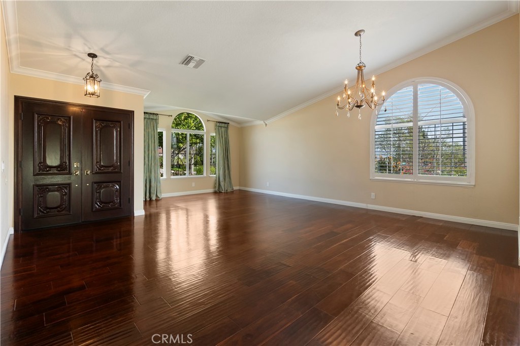 6717 Mission Grove Parkway North Riverside, CA 92506 - Photo 11 of 58 an empty room with wooden floor a chandelier and windows