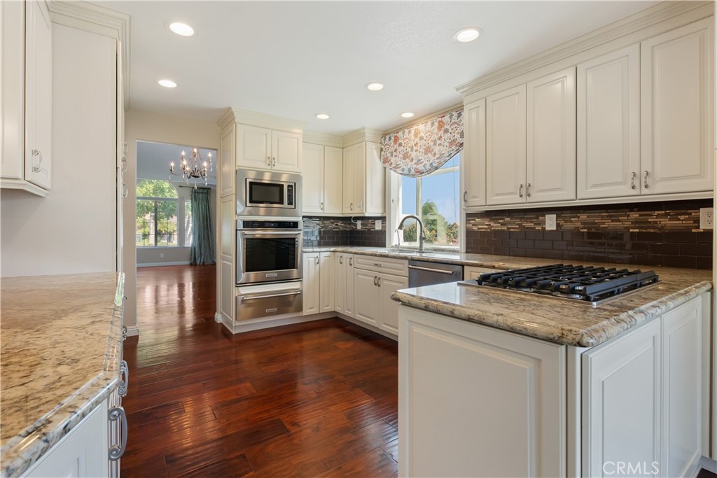 6717 Mission Grove Parkway North Riverside, CA 92506 - Photo 16 of 58 a kitchen with granite countertop a stove top oven and cabinets