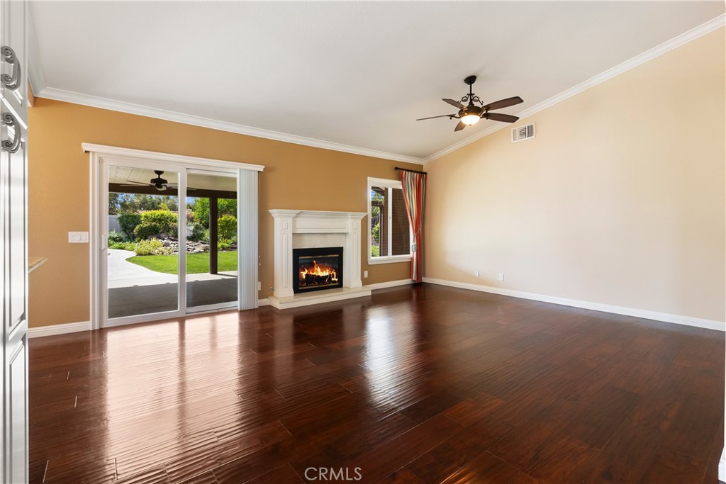 6717 Mission Grove Parkway North Riverside, CA 92506 - Photo 21 of 58 an empty room with wooden floor a ceiling fan and a fireplace