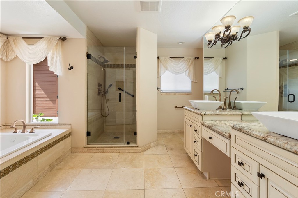 6717 Mission Grove Parkway North Riverside, CA 92506 - Photo 29 of 58 a bathroom with a granite countertop sink a large mirror and a bathtub