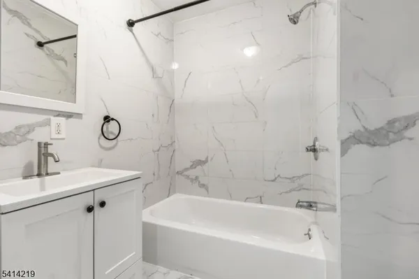 a bathroom with a sink a mirror a bathtub and shower