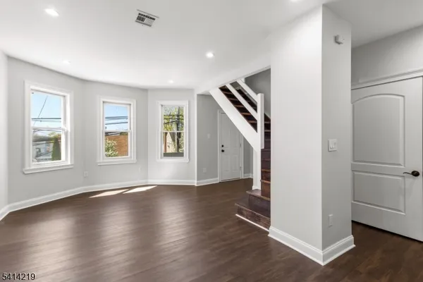 a kitchen with stainless steel appliances and wooden floor