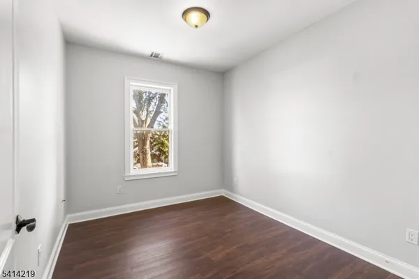 a view of an empty room and wooden floor