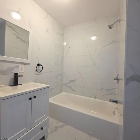 a bathroom with a bathtub a sink a toilet and a mirror