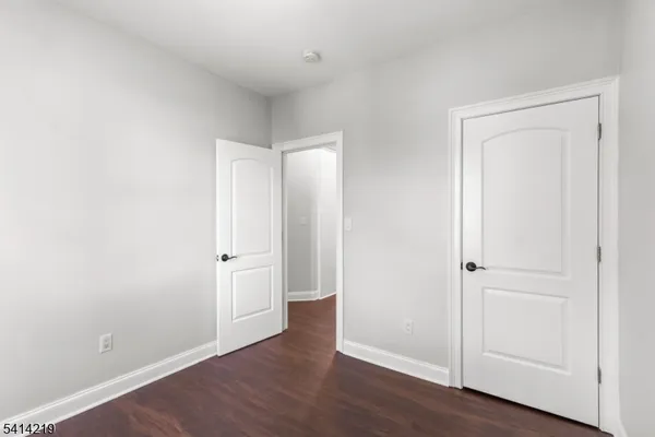 an empty room with wooden floor and closet