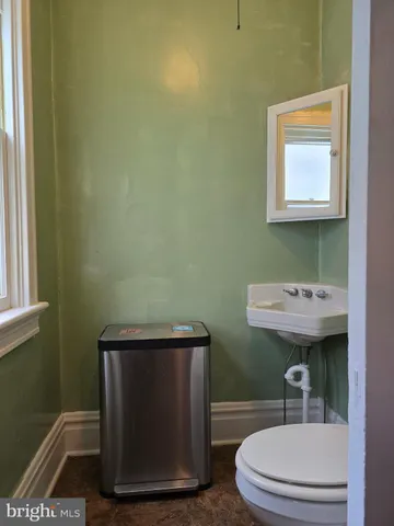 a bathroom with a sink a toilet and a window