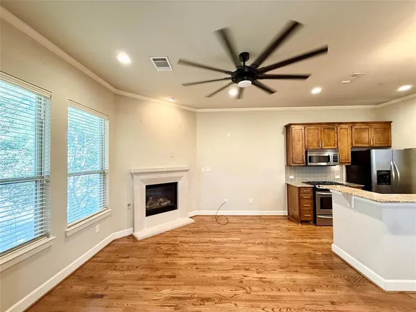 a view of a kitchen with a stove a ceiling fan and wooden floor