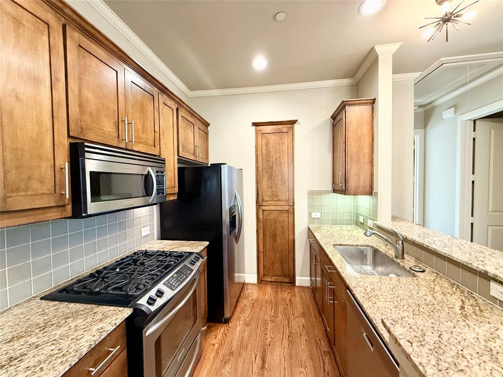 7333 Valley View Lane, Unit 101 Dallas, TX 75240 - Photo 3 of 7 a kitchen with a stove a sink and a refrigerator