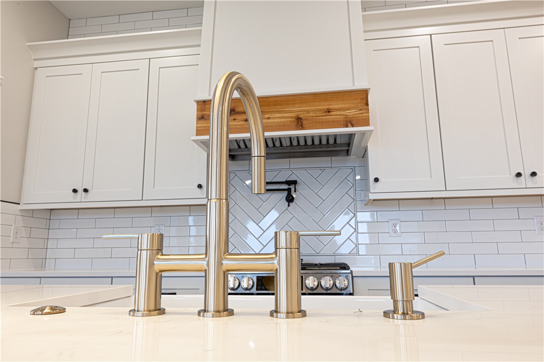 110 Hart Road Anderson, SC 29621 - Photo 18 of 31 This modern kitchen features crisp white cabinetry, a stylish range hood, and a sleek faucet over the sink.