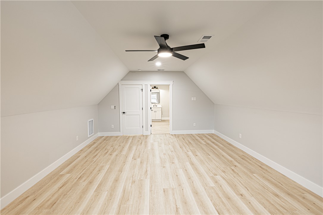 110 Hart Road Anderson, SC 29621 - Photo 27 of 31 This spacious bonus room features sloped ceilings and light wood flooring, offering versatile living space.
