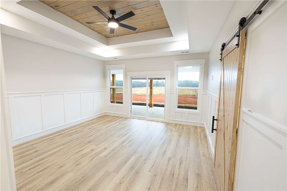 110 Hart Road Anderson, SC 29621 - Photo 10 of 31 This bright bedroom features a distinctive wooden tray ceiling and convenient sliding door access to the outdoors.