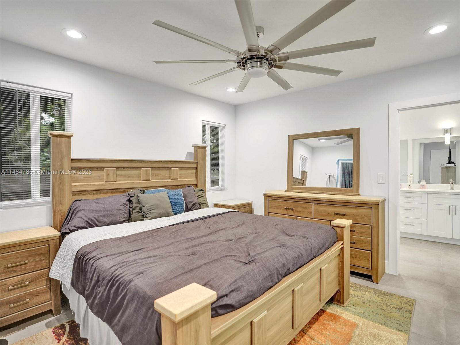 1543 Southwest 32nd Street Fort Lauderdale, FL 33315 - Photo 17 of 33 a bedroom with a large bed and a chandelier