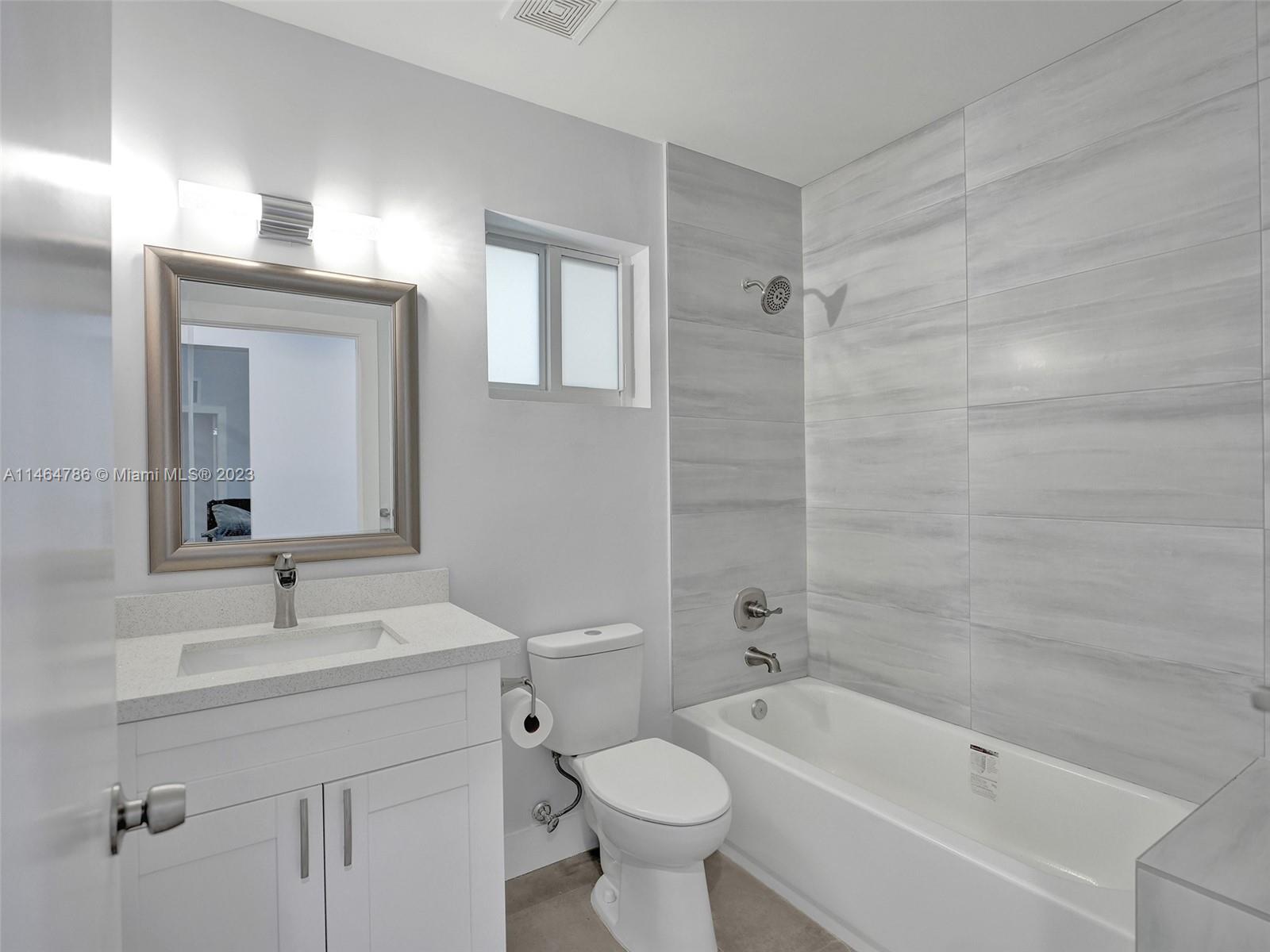 1543 Southwest 32nd Street Fort Lauderdale, FL 33315 - Photo 26 of 33 a bathroom with a bathtub shower sink mirror and toilet