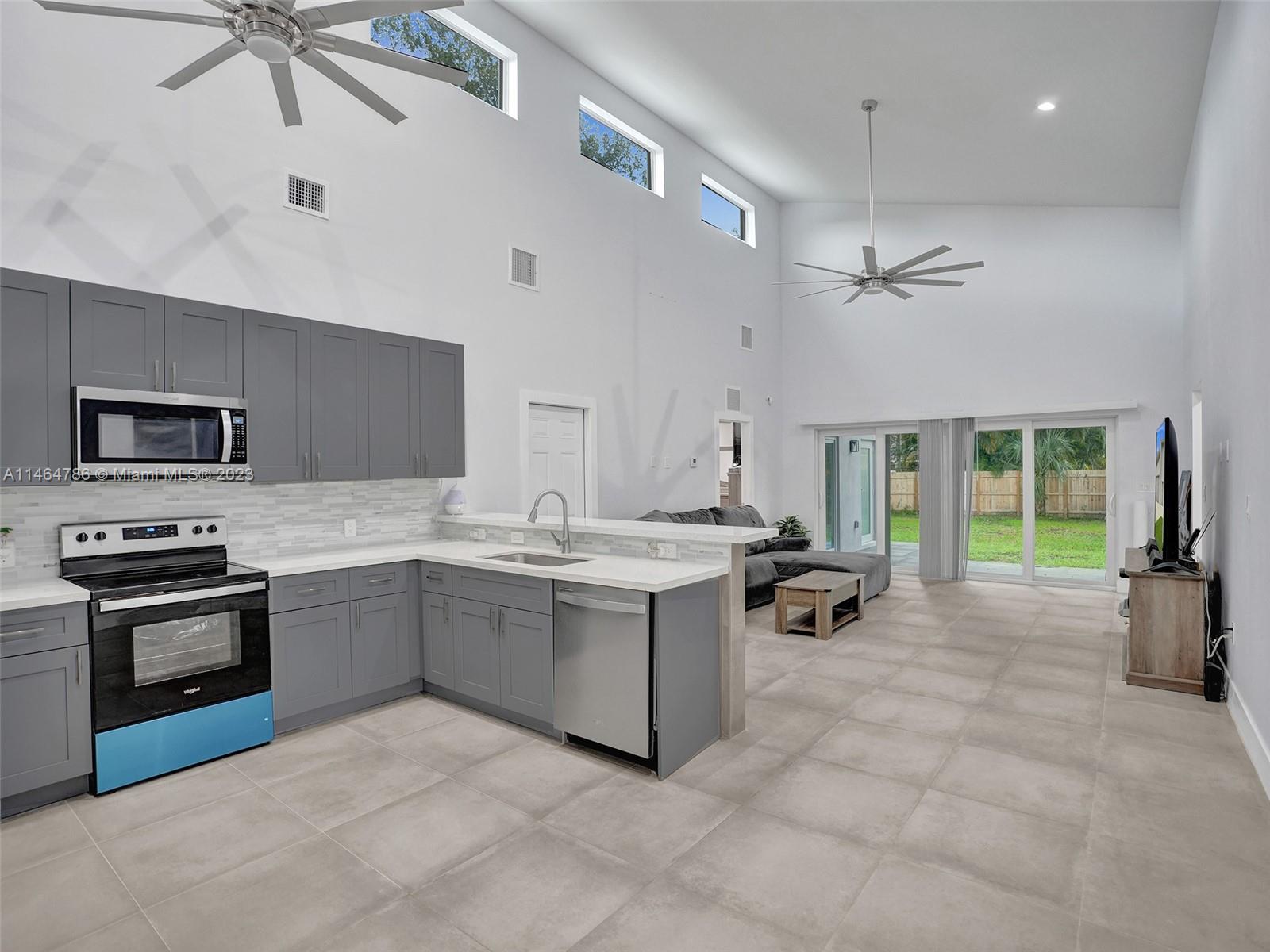 1543 Southwest 32nd Street Fort Lauderdale, FL 33315 - Photo 5 of 33 a kitchen with sink cabinets and stove top oven