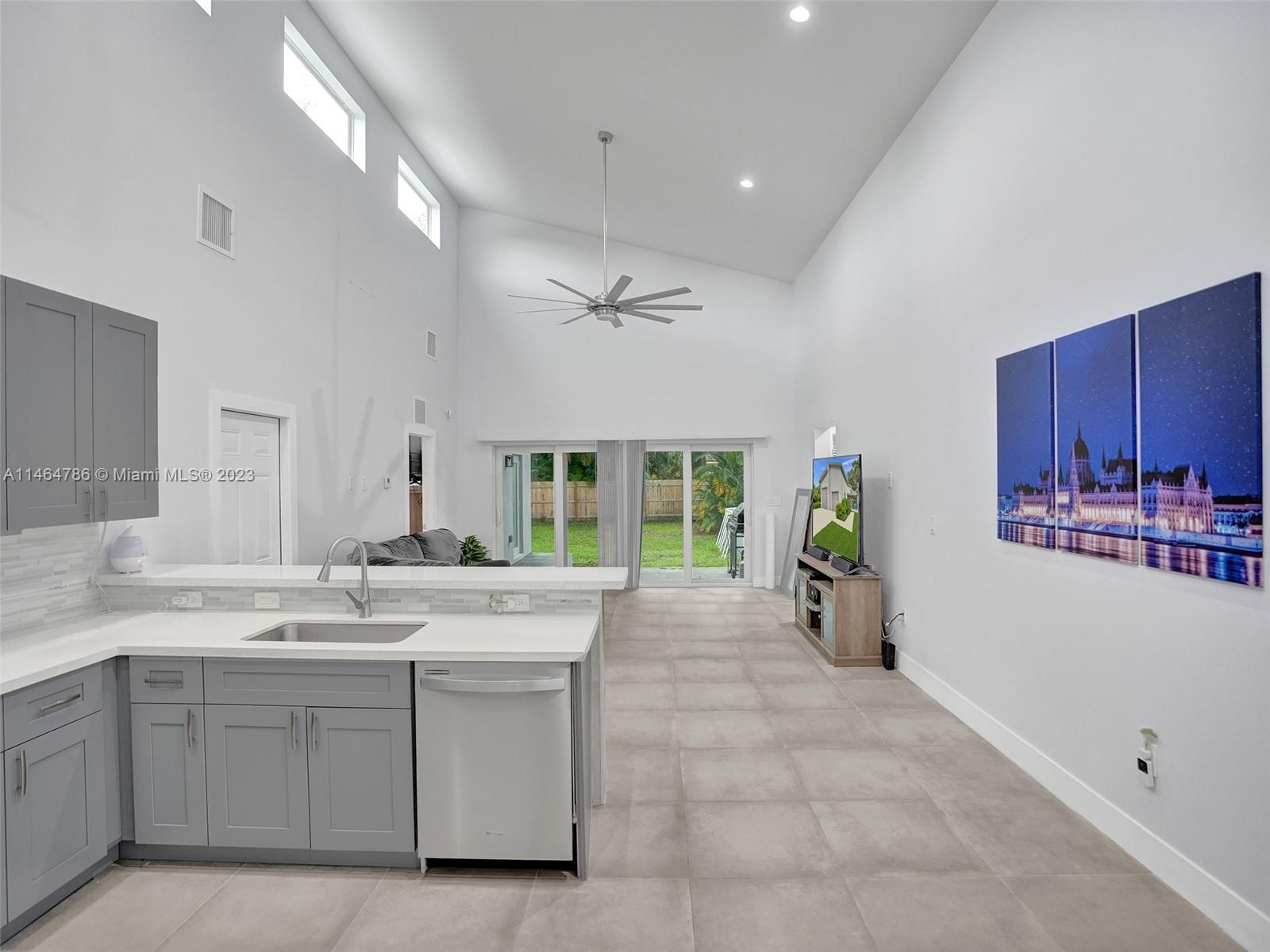 1543 Southwest 32nd Street Fort Lauderdale, FL 33315 - Photo 10 of 33 a large white kitchen with a large window and stainless steel appliances