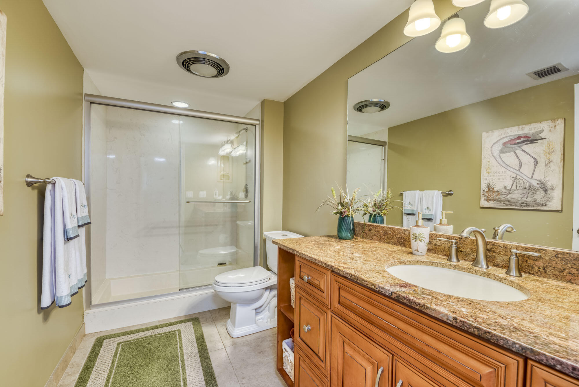 17165 Waterbend Drive, Unit 207 Jupiter, FL 33477 - Photo 18 of 27 a bathroom with a granite countertop sink a toilet a mirror a vanity and shower