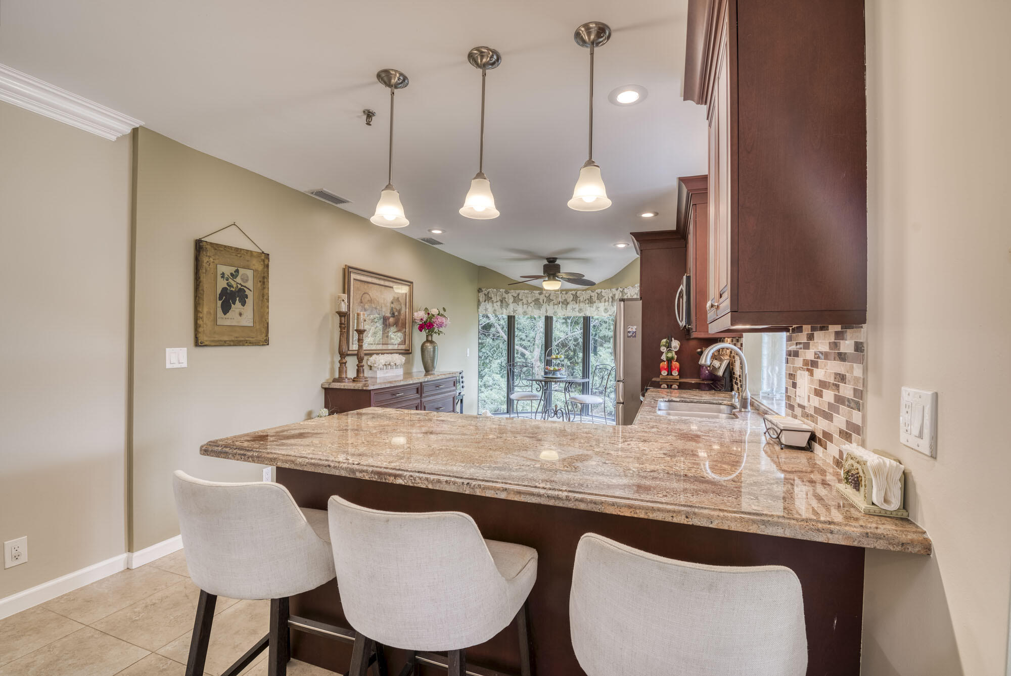 17165 Waterbend Drive, Unit 207 Jupiter, FL 33477 - Photo 8 of 27 a kitchen with granite countertop a table chairs and a chandelier