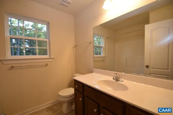 a bathroom with a sink a toilet and a window