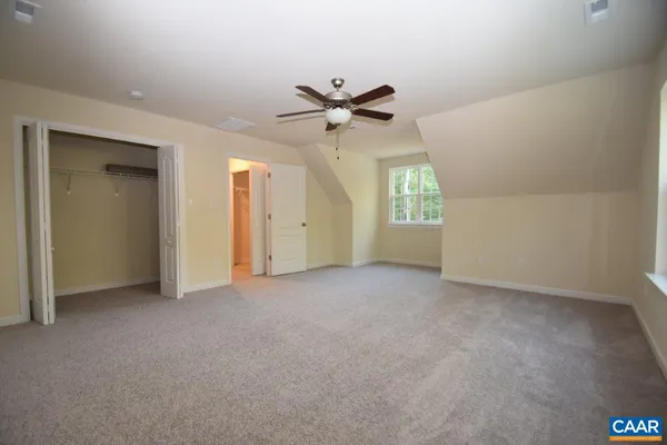 an empty room with a window and a ceiling fan