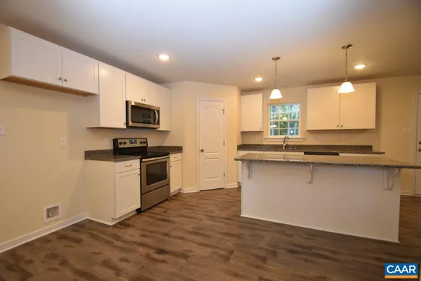 a kitchen with granite countertop a sink cabinets and stainless steel appliances