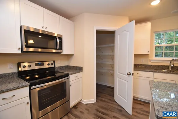 a kitchen with stainless steel appliances granite countertop a stove a microwave and a sink