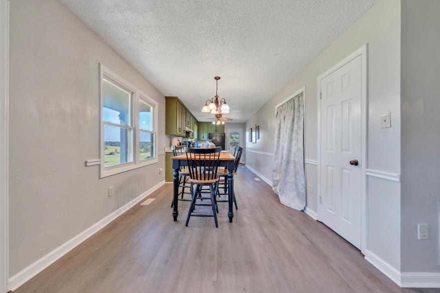 6400 Stewartsville Road Moneta, VA 24121 - Photo 6 of 33 a dining room with furniture a chandelier and wooden floor