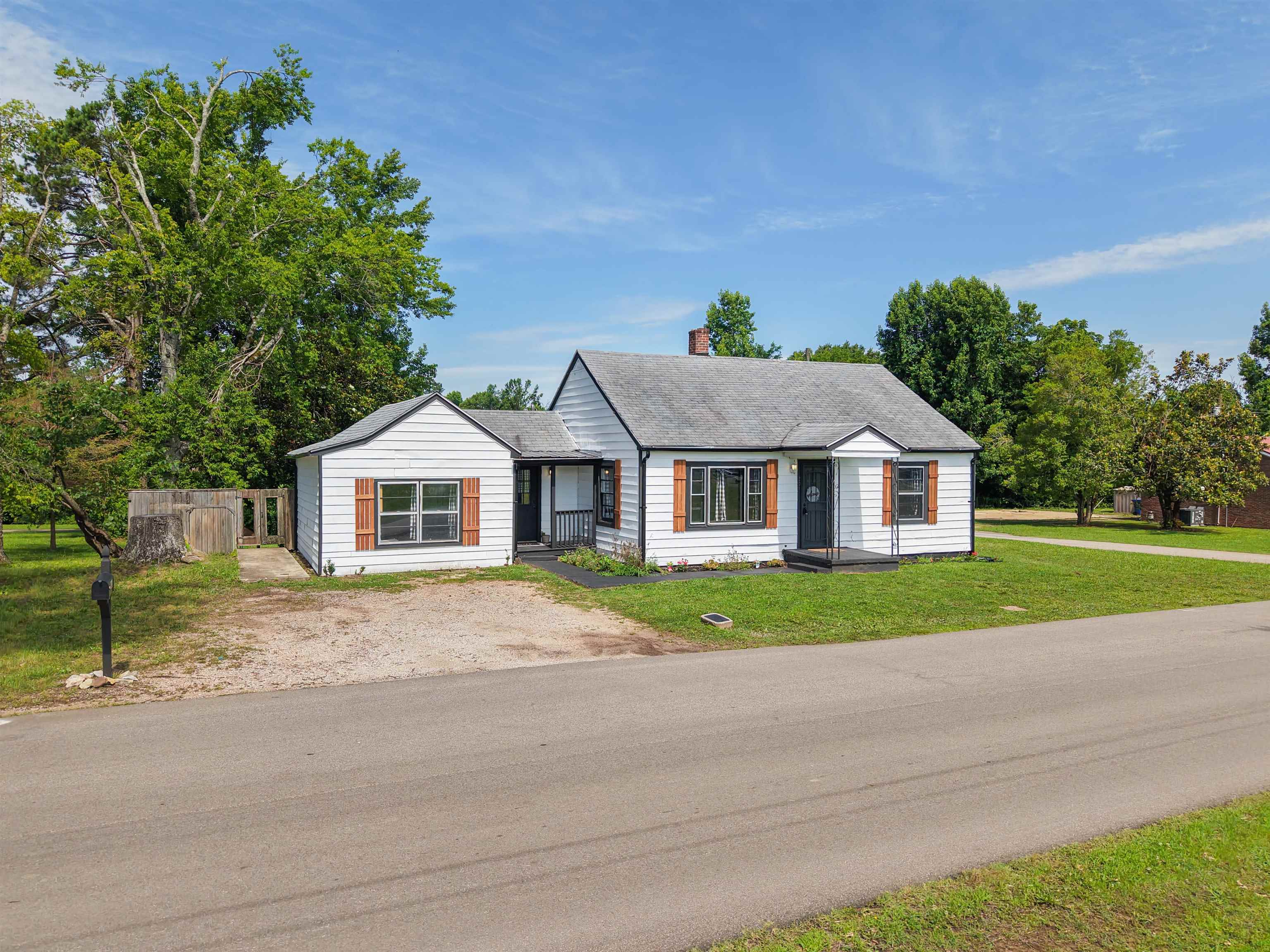 201 Walnut Street Adamsville, TN 38310 - Photo 9 of 26 White siding exterior with dark trim and brown shutters
